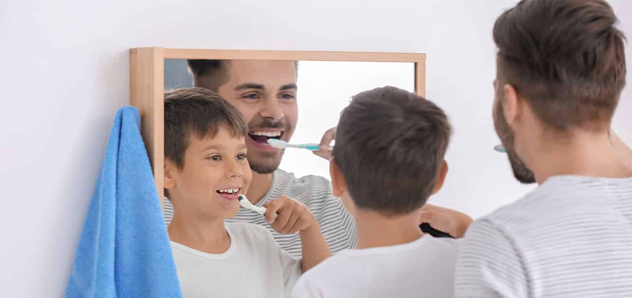 boy and father brushing teeth